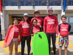 Teachers and students dressed for surfing with boards